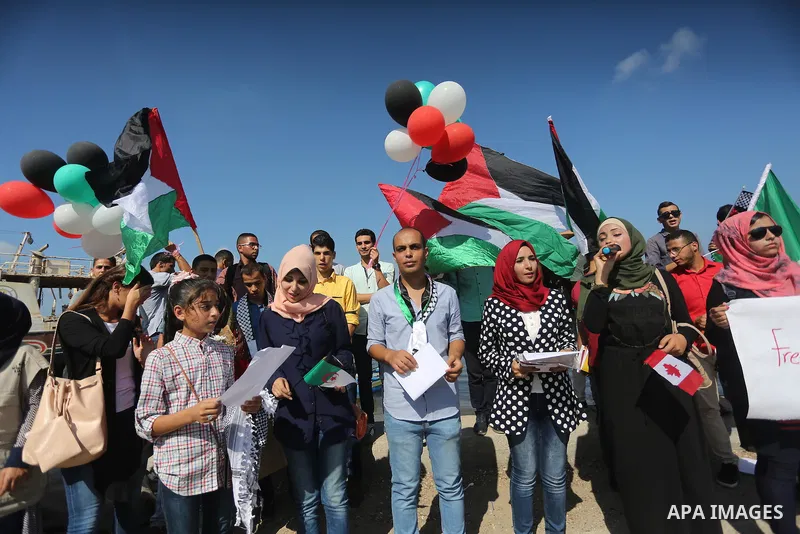 Palestinian youths hold banners during a rally to show solidarity with ship called “Zaytouna” set to arrive in Gaza, at the Seaport of Gaza City October 5, 2016. Photo by Mohammed Asad
