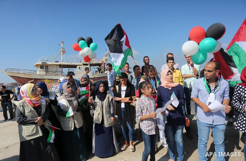 Palestinian youths hold banners during a rally to show solidarity with ship called “Zaytouna” set to arrive in Gaza, at the Seaport of Gaza City October 5, 2016. Photo by Mohammed Asad