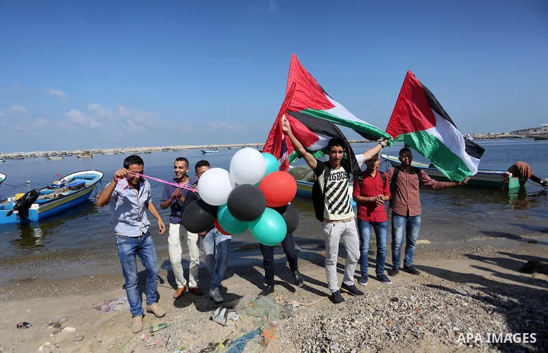 Palestinian youths hold banners during a rally to show solidarity with ship called “Zaytouna” set to arrive in Gaza, at the Seaport of Gaza City October 5, 2016. Photo by Mohammed Asad