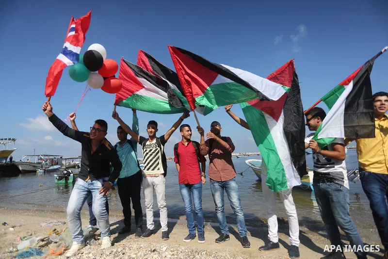 Palestinian youths hold banners during a rally to show solidarity with ship called “Zaytouna” set to arrive in Gaza, at the Seaport of Gaza City October 5, 2016. Photo by Mohammed Asad