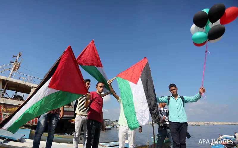 Palestinian youths hold banners during a rally to show solidarity with ship called “Zaytouna” set to arrive in Gaza, at the Seaport of Gaza City October 5, 2016. Photo by Mohammed Asad
