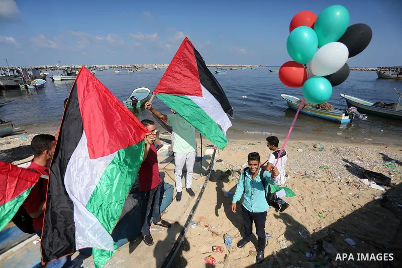 Palestinian youths hold banners during a rally to show solidarity with ship called “Zaytouna” set to arrive in Gaza, at the Seaport of Gaza City October 5, 2016. Photo by Mohammed Asad