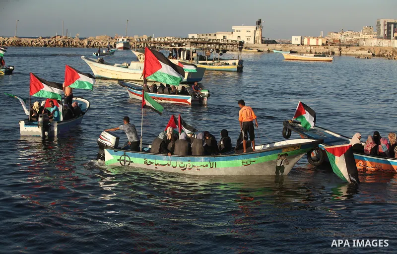 Palestinian women sail boats bearing their national flag in the port of Gaza City in support of the Gaza-bound flotilla of international female activists attempting to break the Israeli blockade on Gaza Strip on October...