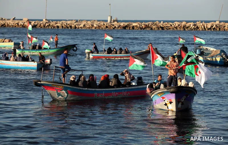 Palestinian women sail boats bearing their national flag in the port of Gaza City in support of the Gaza-bound flotilla of international female activists attempting to break the Israeli blockade on Gaza Strip on October...