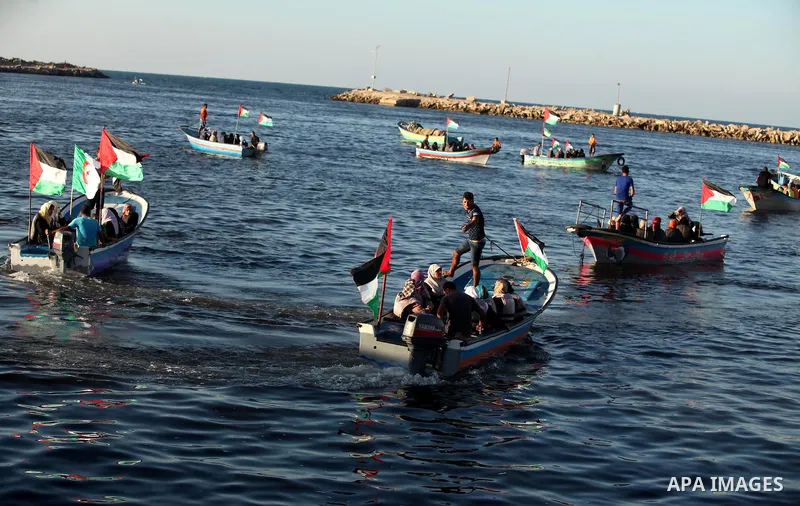 Palestinian women sail boats bearing their national flag in the port of Gaza City in support of the Gaza-bound flotilla of international female activists attempting to break the Israeli blockade on Gaza Strip on October...