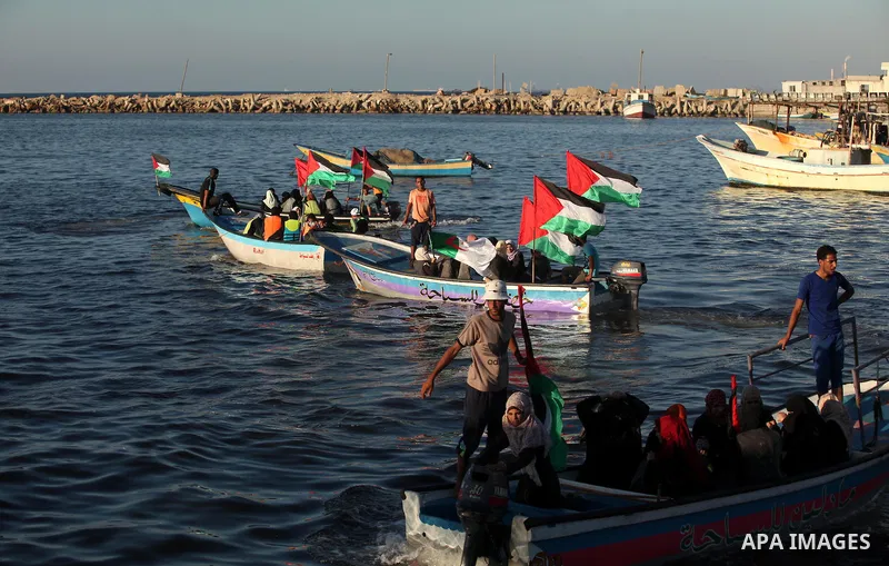 Palestinian women sail boats bearing their national flag in the port of Gaza City in support of the Gaza-bound flotilla of international female activists attempting to break the Israeli blockade on Gaza Strip on October...