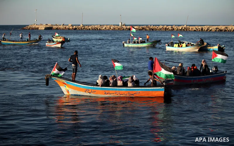 Palestinian women sail boats bearing their national flag in the port of Gaza City in support of the Gaza-bound flotilla of international female activists attempting to break the Israeli blockade on Gaza Strip on October...