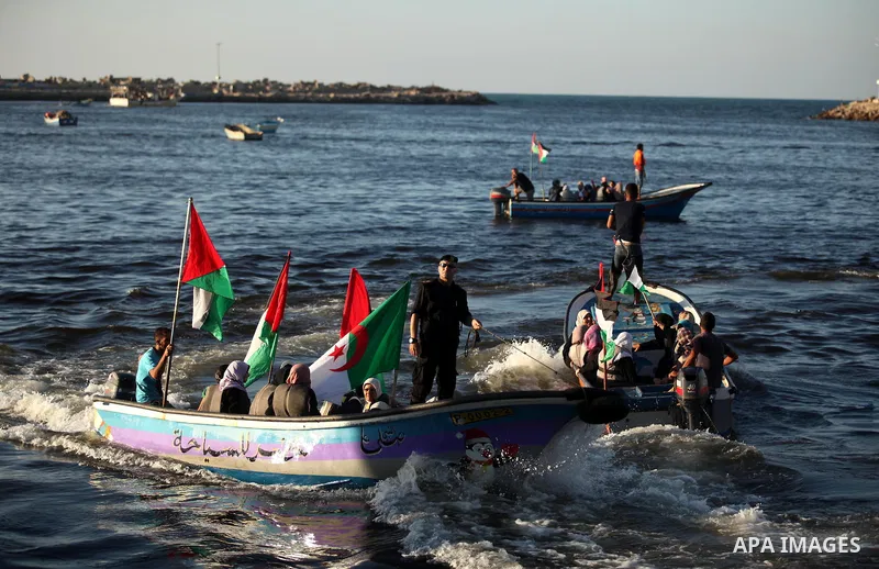 Palestinian women sail boats bearing their national flag in the port of Gaza City in support of the Gaza-bound flotilla of international female activists attempting to break the Israeli blockade on Gaza Strip on October...