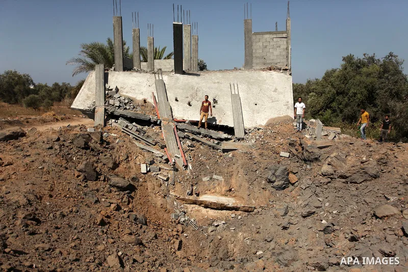 Palestinians inspect the scene of what witnesses said was an Israeli air strike carried out on Wednesday, east of Gaza City October 6, 2016. Photo by Ashraf Amra