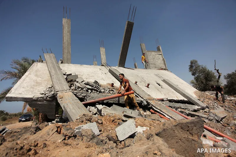 Palestinians inspect the scene of what witnesses said was an Israeli air strike carried out on Wednesday, east of Gaza City October 6, 2016. Photo by Ashraf Amra