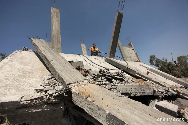 Palestinians inspect the scene of what witnesses said was an Israeli air strike carried out on Wednesday, east of Gaza City October 6, 2016. Photo by Ashraf Amra