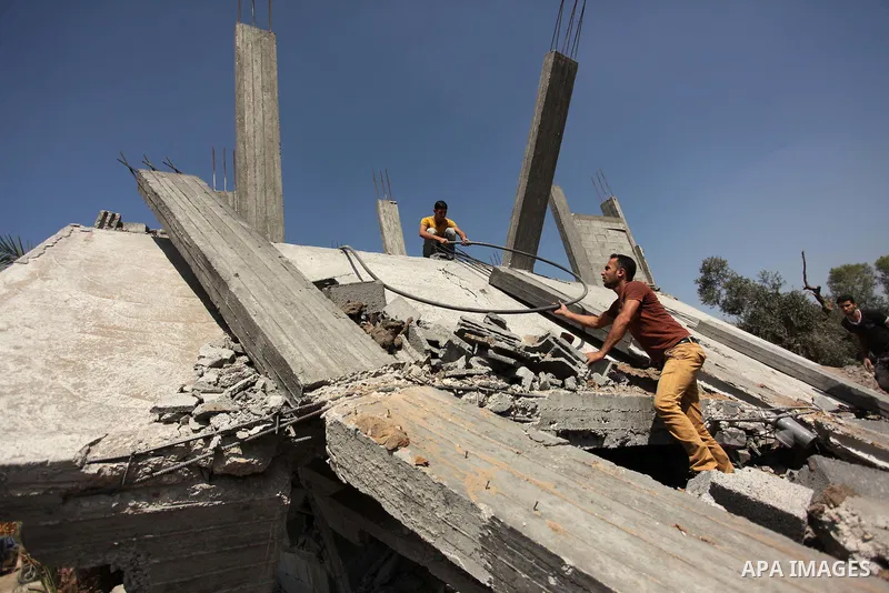 Palestinians inspect the scene of what witnesses said was an Israeli air strike carried out on Wednesday, east of Gaza City October 6, 2016. Photo by Ashraf Amra