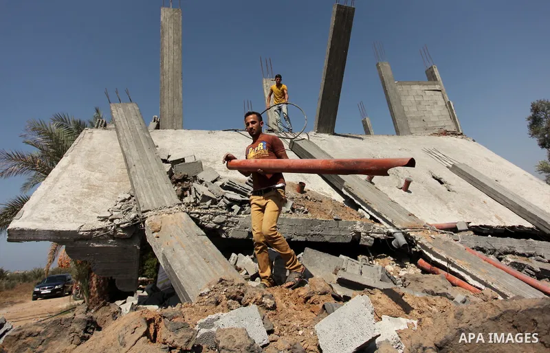 Palestinians inspect the scene of what witnesses said was an Israeli air strike carried out on Wednesday, east of Gaza City October 6, 2016. Photo by Ashraf Amra