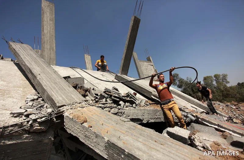 Palestinians inspect the scene of what witnesses said was an Israeli air strike carried out on Wednesday, east of Gaza City October 6, 2016. Photo by Ashraf Amra
