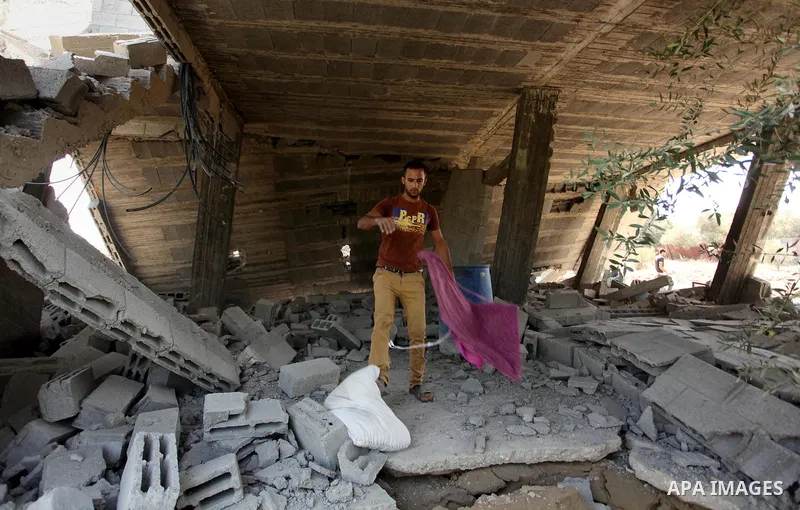 Palestinians inspect the scene of what witnesses said was an Israeli air strike carried out on Wednesday, east of Gaza City October 6, 2016. Photo by Ashraf Amra