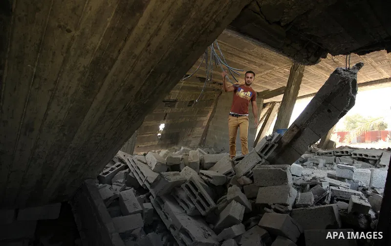 Palestinians inspect the scene of what witnesses said was an Israeli air strike carried out on Wednesday, east of Gaza City October 6, 2016. Photo by Ashraf Amra