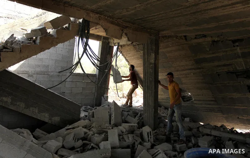 Palestinians inspect the scene of what witnesses said was an Israeli air strike carried out on Wednesday, east of Gaza City October 6, 2016. Photo by Ashraf Amra