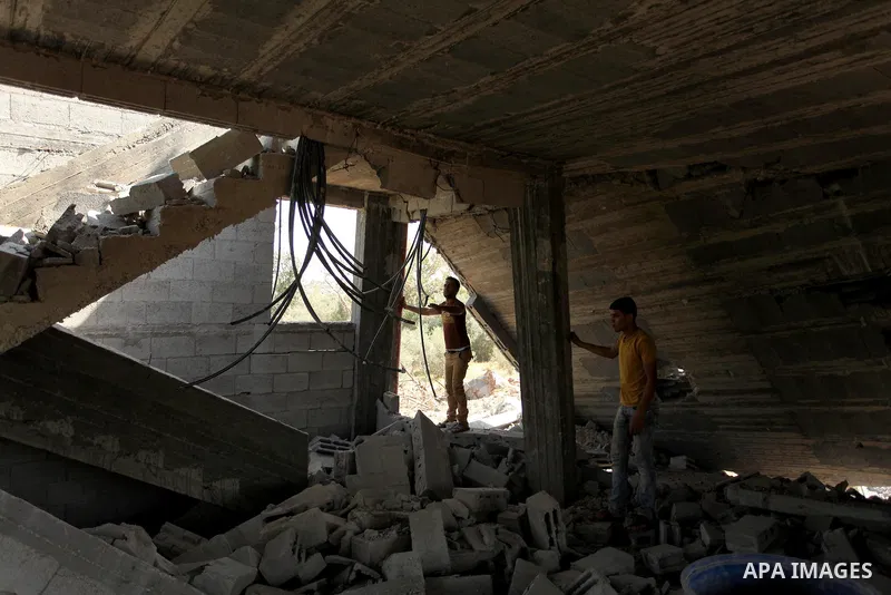 Palestinians inspect the scene of what witnesses said was an Israeli air strike carried out on Wednesday, east of Gaza City October 6, 2016. Photo by Ashraf Amra