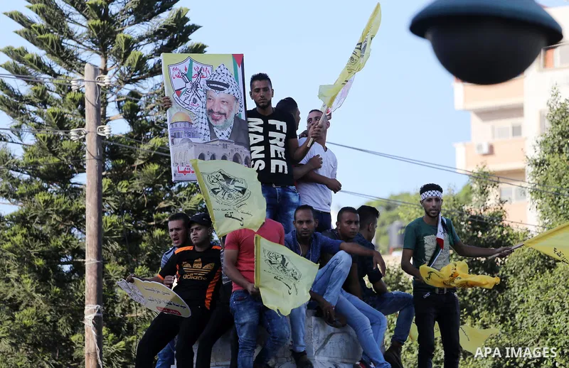 Palestinians who support Palestinian senior Fatah official Mohammed Dahlan, hold banners and national flags during a protest against Palestinian President Mahmoud Abbas in Gaza City on Oct. 06, 2016. Photo by Mohammed As...