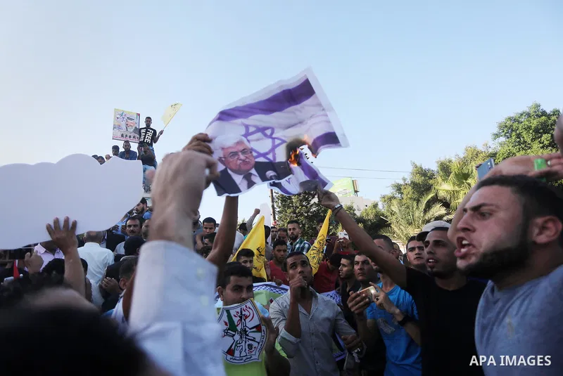 Palestinians who support Palestinian senior Fatah official Mohammed Dahlan burn crossed posters of Palestinian President Mahmoud Abbas and Israeli flags during a protest in Gaza City on Oct. 06, 2016. Photo by Mohammed A...