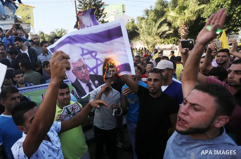 Palestinians who support Palestinian senior Fatah official Mohammed Dahlan burn crossed posters of Palestinian President Mahmoud Abbas and Israeli flags during a protest in Gaza City on Oct. 06, 2016. Photo by Mohammed A...