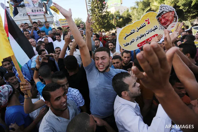 Palestinians who support Palestinian senior Fatah official Mohammed Dahlan, hold banners and national flags during a protest against Palestinian President Mahmoud Abbas in Gaza City on Oct. 06, 2016. Photo by Mohammed As...