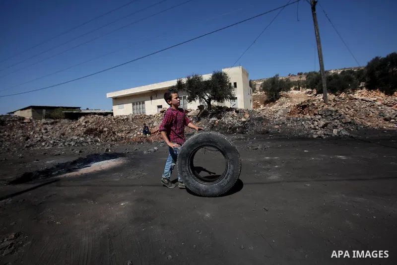 A Palestinian protester burns tires during clashes with Israeli security forces following a weekly demonstration against the expropriation of Palestinian land by Israel on October 6, 2016, in the village of Kfar Qaddum,...
