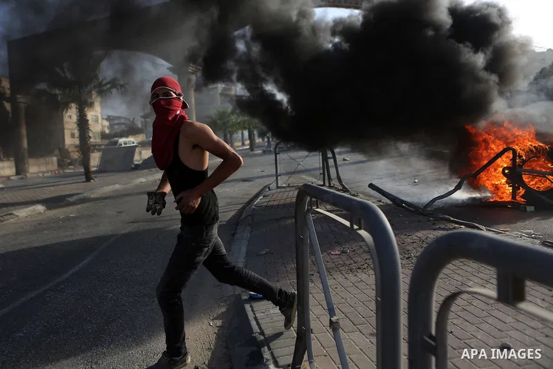 A Palestinian protester hurls stones towards Israeli border policemen during clashes in the West Bank town of Al-Ram, near Jerusalem October 9, 2016. A Palestinian opened fire from a car in Jerusalem on Sunday and again...