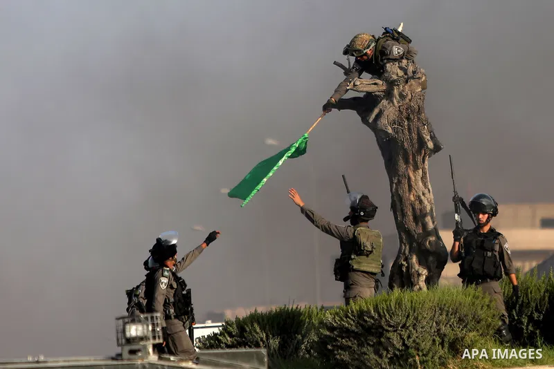 An Israeli border policeman removes a Hamas flag during clashes with Palestinian protesters in the West Bank town of Al-Ram, near Jerusalem October 9, 2016. A Palestinian opened fire from a car in Jerusalem on Sunday and...