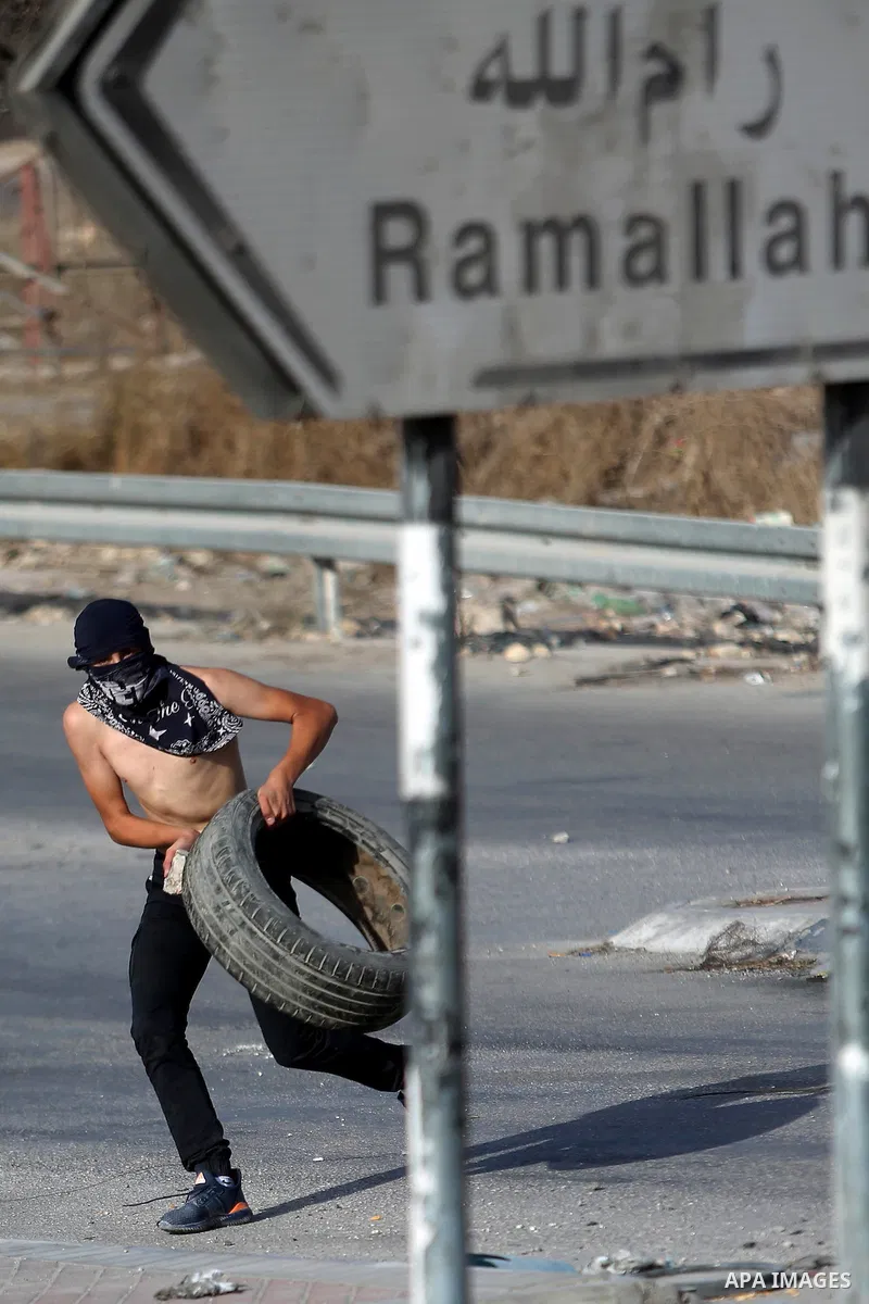 A Palestinian protester carries tires during clashes with Israeli border policemen in the West Bank town of Al-Ram, near Jerusalem October 9, 2016. A Palestinian opened fire from a car in Jerusalem on Sunday and again as...