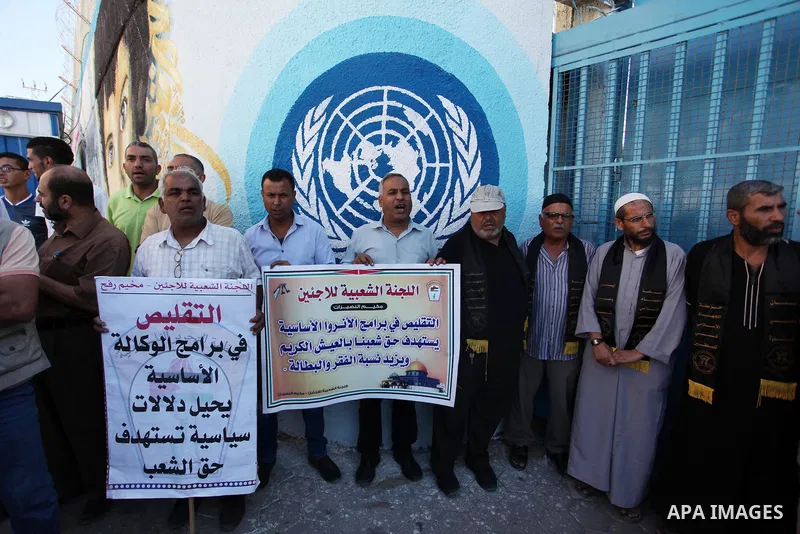 Palestinians hold banners during a protest against the UNRWA decision to reduce of the aid in front of the headquarters United Nations Relief and Works Agency (UNRWA), in Gaza city on October 11, 2016. Photo by Ashraf Am...