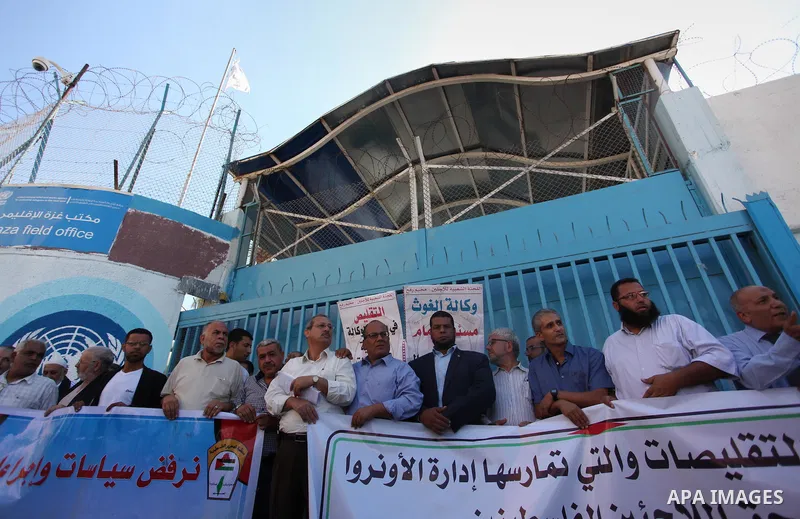 Palestinians hold banners during a protest against the UNRWA decision to reduce of the aid in front of the headquarters United Nations Relief and Works Agency (UNRWA), in Gaza city on October 11, 2016. Photo by Ashraf Am...