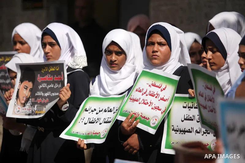 Palestinian students hold banners during a protest to show solidarity with the child prisoners in Israeli jails, in front of Red cross office in Gaza city, on October 13, 2016. Photo by Ashraf Amra