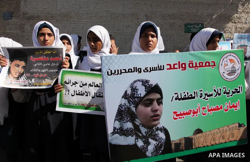 Palestinian students hold banners during a protest to show solidarity with the child prisoners in Israeli jails, in front of Red cross office in Gaza city, on October 13, 2016. Photo by Ashraf Amra