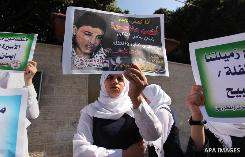 Palestinian students hold banners during a protest to show solidarity with the child prisoners in Israeli jails, in front of Red cross office in Gaza city, on October 13, 2016. Photo by Ashraf Amra