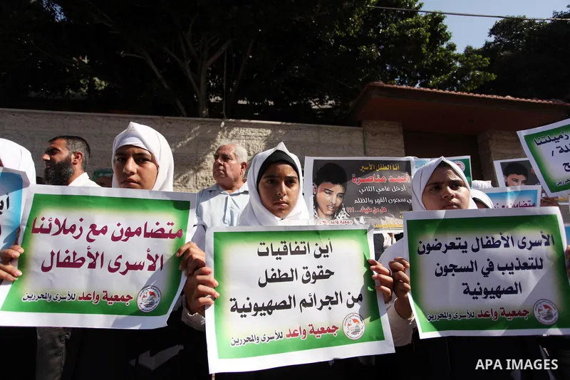 Palestinian students hold banners during a protest to show solidarity with the child prisoners in Israeli jails, in front of Red cross office in Gaza city, on October 13, 2016. Photo by Ashraf Amra