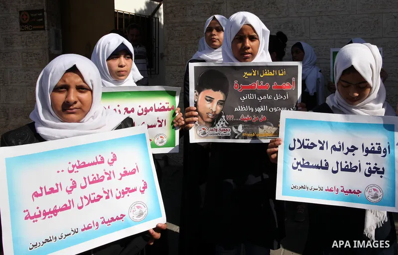 Palestinian students hold banners during a protest to show solidarity with the child prisoners in Israeli jails, in front of Red cross office in Gaza city, on October 13, 2016. Photo by Ashraf Amra
