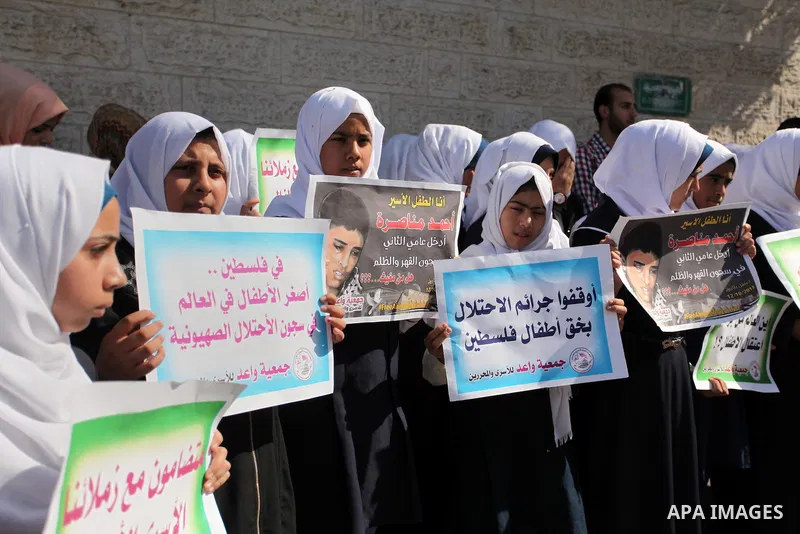 Palestinian students hold banners during a protest to show solidarity with the child prisoners in Israeli jails, in front of Red cross office in Gaza city, on October 13, 2016. Photo by Ashraf Amra
