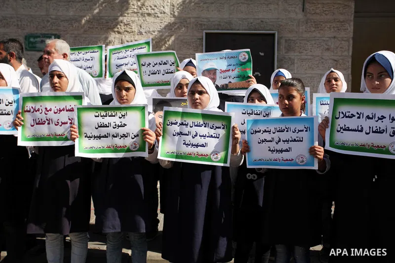 Palestinian students hold banners during a protest to show solidarity with the child prisoners in Israeli jails, in front of Red cross office in Gaza city, on October 13, 2016. Photo by Ashraf Amra