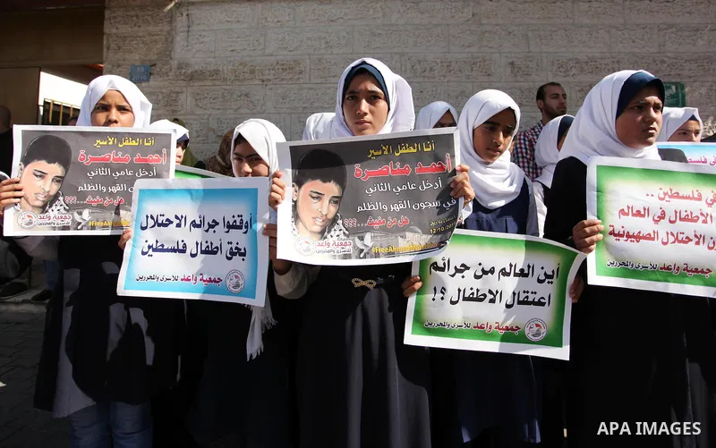 Palestinian students hold banners during a protest to show solidarity with the child prisoners in Israeli jails, in front of Red cross office in Gaza city, on October 13, 2016. Photo by Ashraf Amra