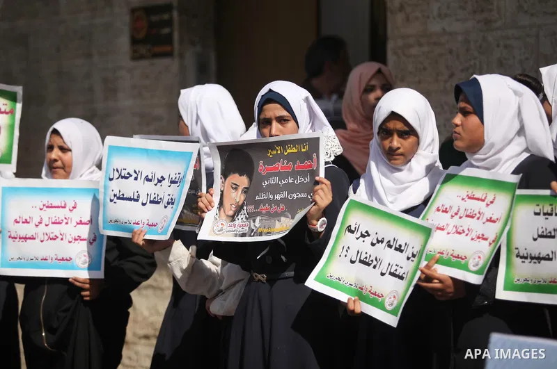 Palestinian students hold banners during a protest to show solidarity with the child prisoners in Israeli jails, in front of Red cross office in Gaza city, on October 13, 2016. Photo by Ashraf Amra