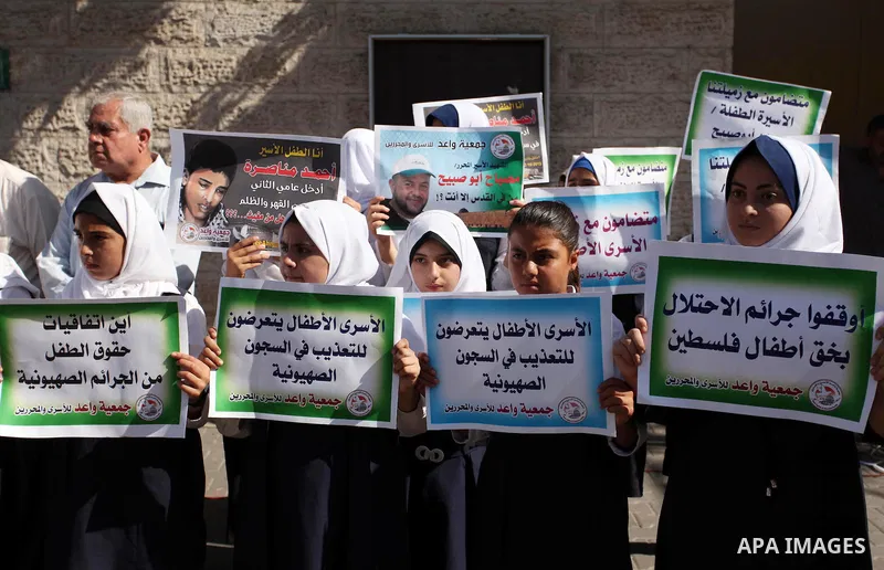 Palestinian students hold banners during a protest to show solidarity with the child prisoners in Israeli jails, in front of Red cross office in Gaza city, on October 13, 2016. Photo by Ashraf Amra