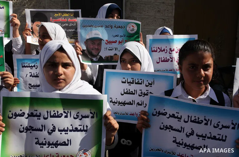 Palestinian students hold banners during a protest to show solidarity with the child prisoners in Israeli jails, in front of Red cross office in Gaza city, on October 13, 2016. Photo by Ashraf Amra