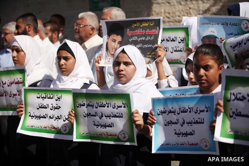 Palestinian students hold banners during a protest to show solidarity with the child prisoners in Israeli jails, in front of Red cross office in Gaza city, on October 13, 2016. Photo by Ashraf Amra