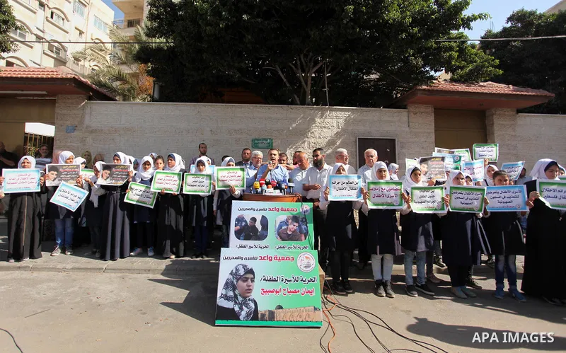 Palestinian students hold banners during a protest to show solidarity with the child prisoners in Israeli jails, in front of Red cross office in Gaza city, on October 13, 2016. Photo by Ashraf Amra