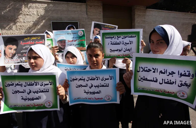 Palestinian students hold banners during a protest to show solidarity with the child prisoners in Israeli jails, in front of Red cross office in Gaza city, on October 13, 2016. Photo by Ashraf Amra