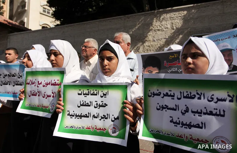 Palestinian students hold banners during a protest to show solidarity with the child prisoners in Israeli jails, in front of Red cross office in Gaza city, on October 13, 2016. Photo by Ashraf Amra