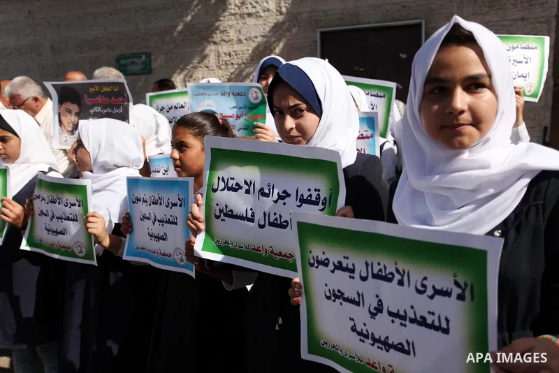Palestinian students hold banners during a protest to show solidarity with the child prisoners in Israeli jails, in front of Red cross office in Gaza city, on October 13, 2016. Photo by Ashraf Amra