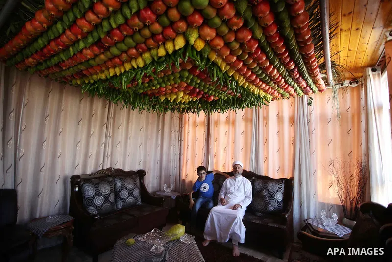 A member of the Samaritan sect decorates a traditional hut known as a sukkot with fruits and vegetables on Mount Gerizim, on the outskirts of the West Bank city of Nablus, October 13, 2016. A sukkot is a ritual hut used...