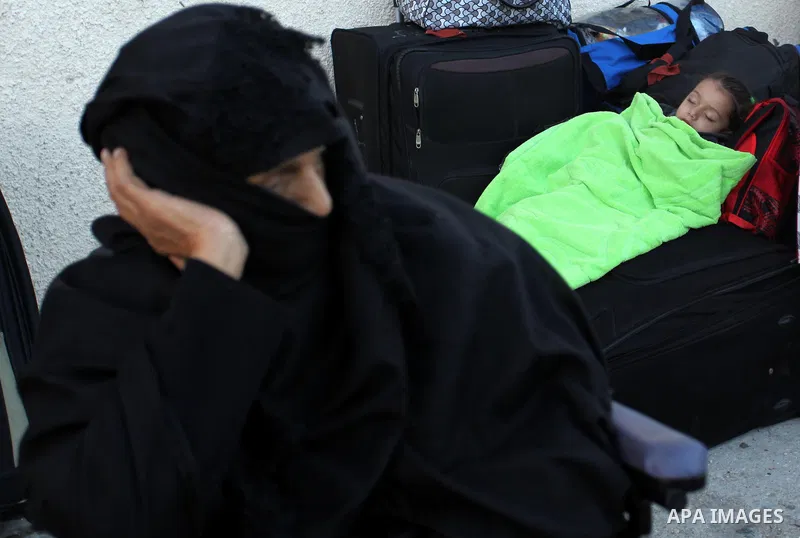 A Palestinian girl sleeps on a suitcase as she waits with her family for a travel permit to cross into Egypt through the Rafah border crossing on October 15, 2016 in the southern Gaza Strip. Egyptian authorities temporar...